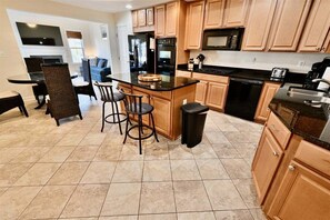 A kitchen with wooden cabinets, a black countertop, and a built-in oven.