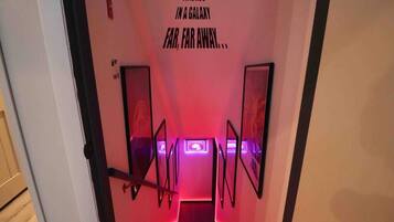En smal gang med et rødt neonlys der står: "FOR LÆNGST SIDEN I EN GALAKSE LANGT, LANGT UNNA...".