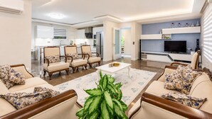 Un salon moderne avec un canapé, une table basse et un téléviseur.