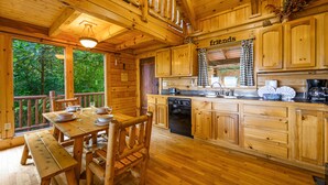 A wooden cabin with a dining area, kitchen, and a sign reading "friends". - Free Attractions | Secluded, New Hot Tub w/ Views, Fireplace, Pet-Friendly (Gatlinburg)