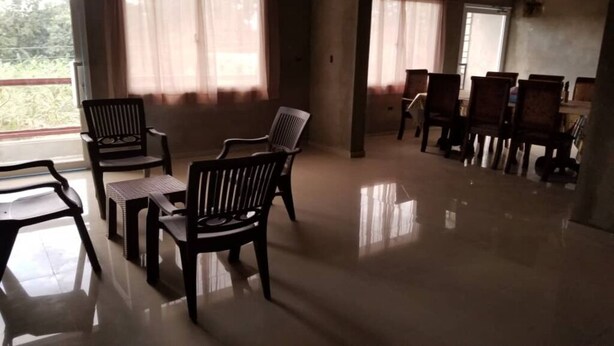 A spacious room with a polished floor, several wooden chairs, and a dining table. - Close to the Border of Dominican Republic (Cap-Haitien)