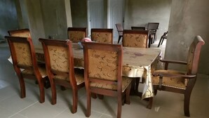 A dining area with a rectangular table and six chairs, each with floral upholstery. - Close to the Border of Dominican Republic (Cap-Haitien)