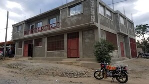 A two-story building with a balcony and a red door. - Close to the Border of Dominican Republic (Cap-Haitien)
