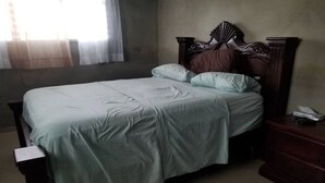 A bedroom with a single bed, a nightstand, and a telephone. - Close to the Border of Dominican Republic (Cap-Haitien)