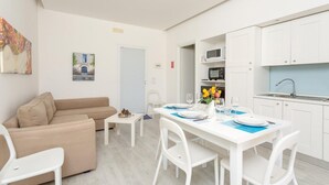 Eine moderne, gut beleuchtete Wohnung mit Wohnbereich, Essplatz und Küche.