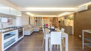 A modern kitchen with a dining area, built-in cabinets, and a central island. - Villa Palazzola - Five Bedroom Villa, Sleeps 12 (Scicli)