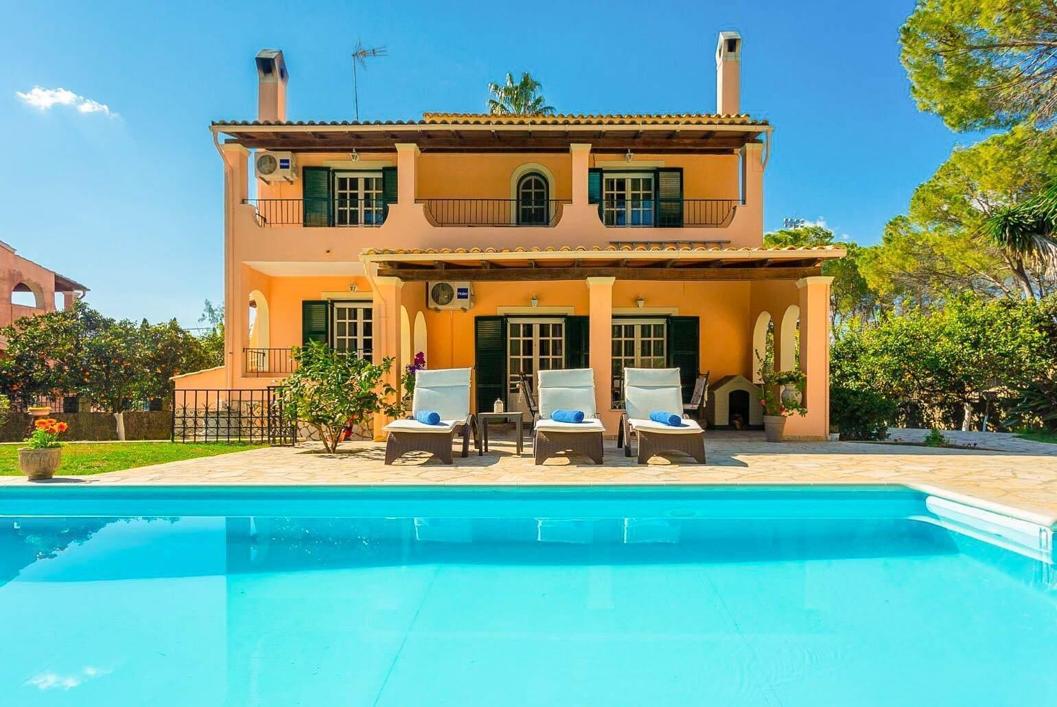 A two-story house with a swimming pool in front.