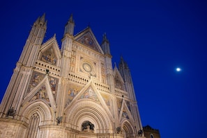A Gothic cathedral with intricate facade and rose window, under a clear night sky. - Villa Le Balze Large Private Pool, WiFi (Vinci)