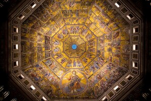 A detailed, circular mosaic ceiling with intricate artwork and a central figure.