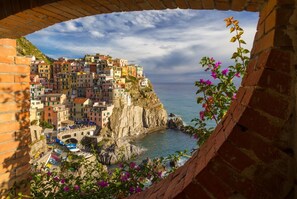 A coastal town with colorful buildings, a rocky shoreline, and a clear view of the sea.