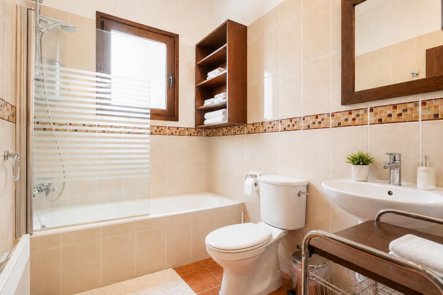 A bathroom with a shower, toilet, sink, and a mirror.