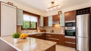 A modern kitchen with granite countertops, stainless steel appliances, and wooden cabinets.