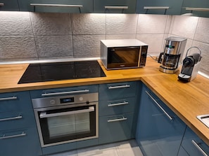 A modern kitchen with a built-in microwave, coffee maker, and oven.