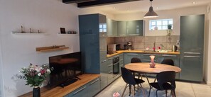 Una cocina moderna con comedor, electrodomésticos integrados y un amplio ventanal.