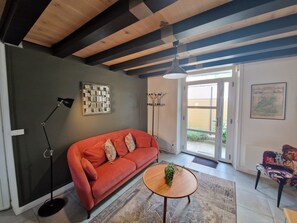 Un salon moderne avec un canapé rouge, une table basse en bois et un lampadaire.