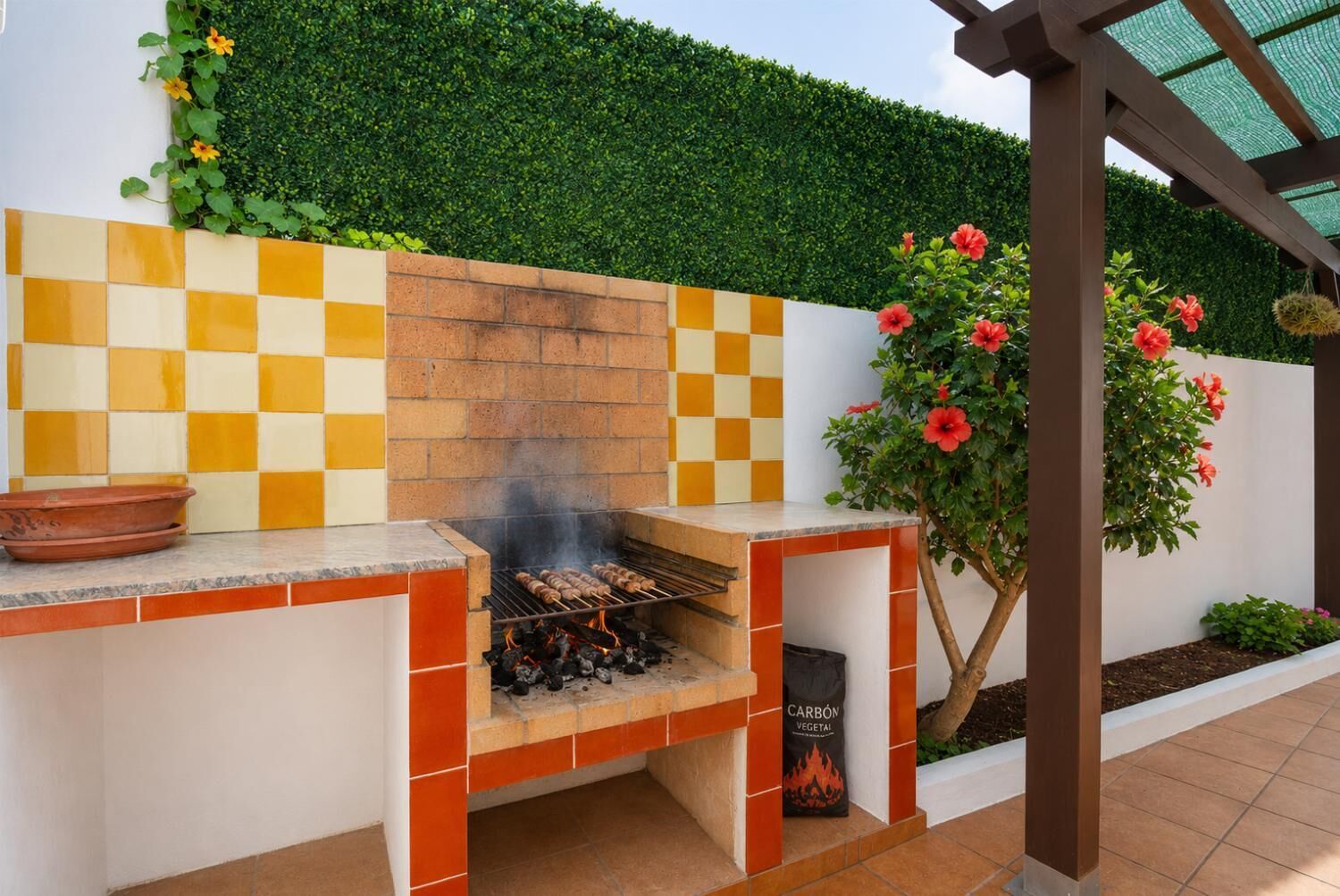 Una cocina exterior con una parrilla, un horno de ladrillo y un salpicadero de baldosas a cuadros.