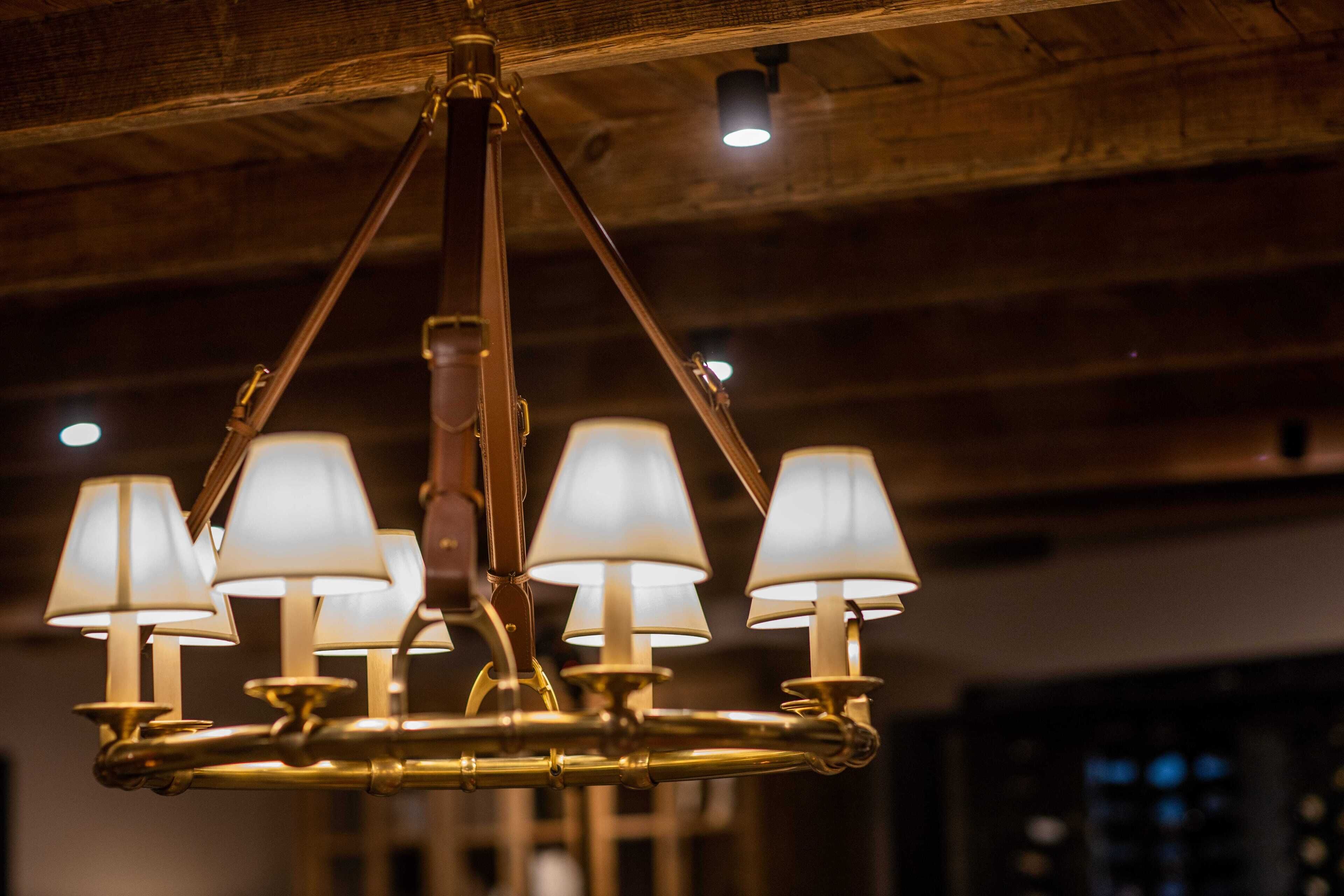 Un lustre doté de plusieurs abat-jours suspendus à un plafond en bois.