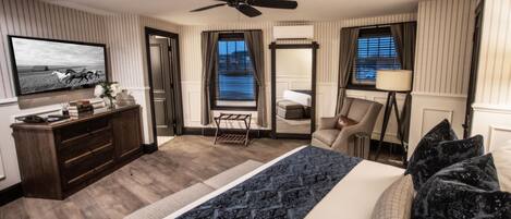 Une chambre d’hôtel équipée d’un lit, d’un bureau, d’une chaise, d’une télévision et d’un ventilateur de plafond.