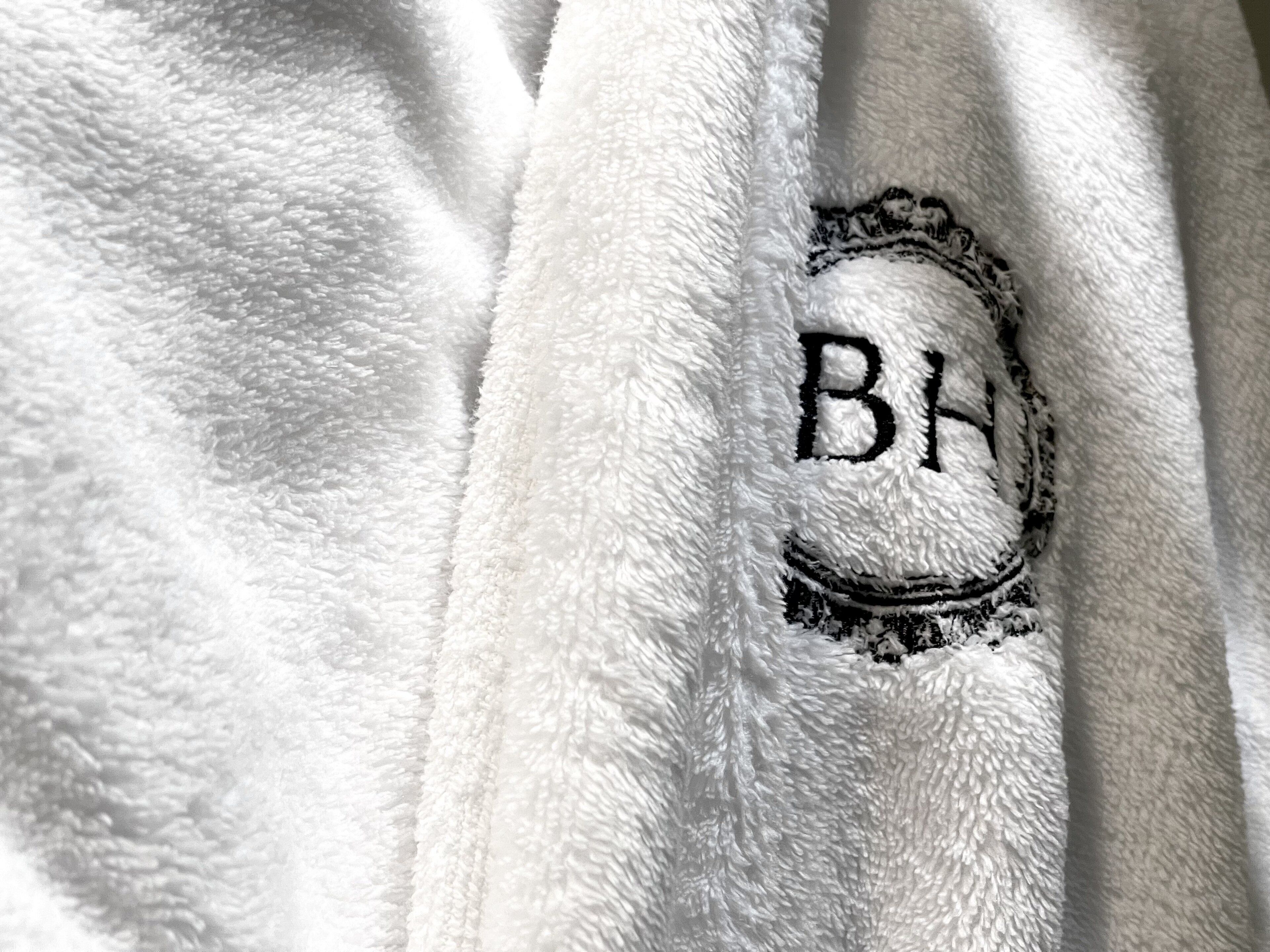 Una toalla blanca con un monograma "BH" bordado.