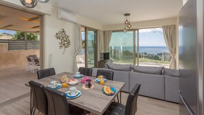 Un comedor moderno con una mesa de madera, sillas negras y un sofá.
