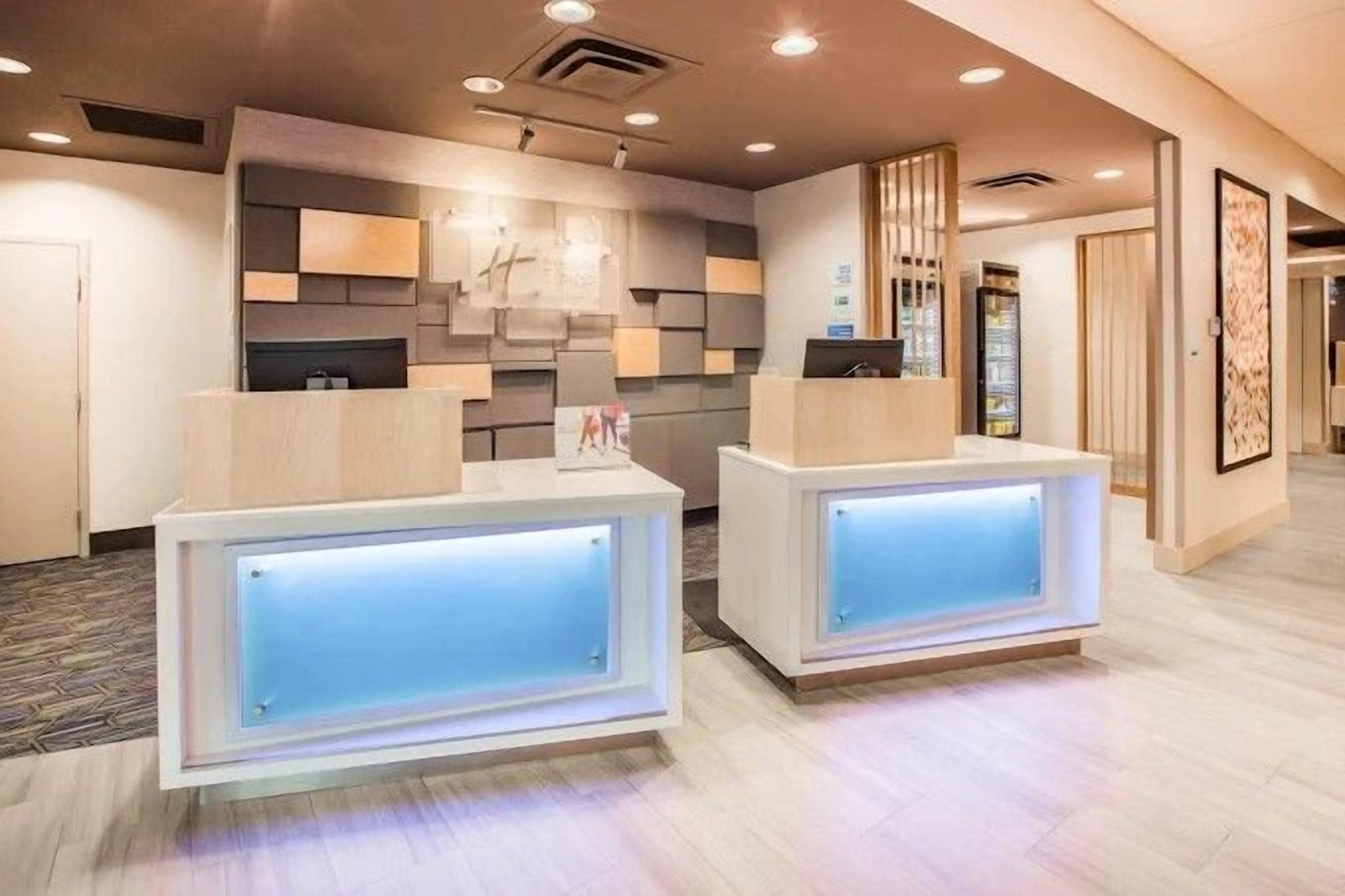 Un área de recepción con dos mostradores, diseño interior moderno y un televisor de pared visible.