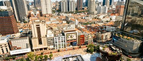 Un paisaje urbano con una mezcla de arquitectura moderna y tradicional, incluyendo un edificio destacado con un gran anuncio.