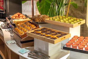 Un buffet proposant une variété de pùtisseries et de produits de boulangerie.