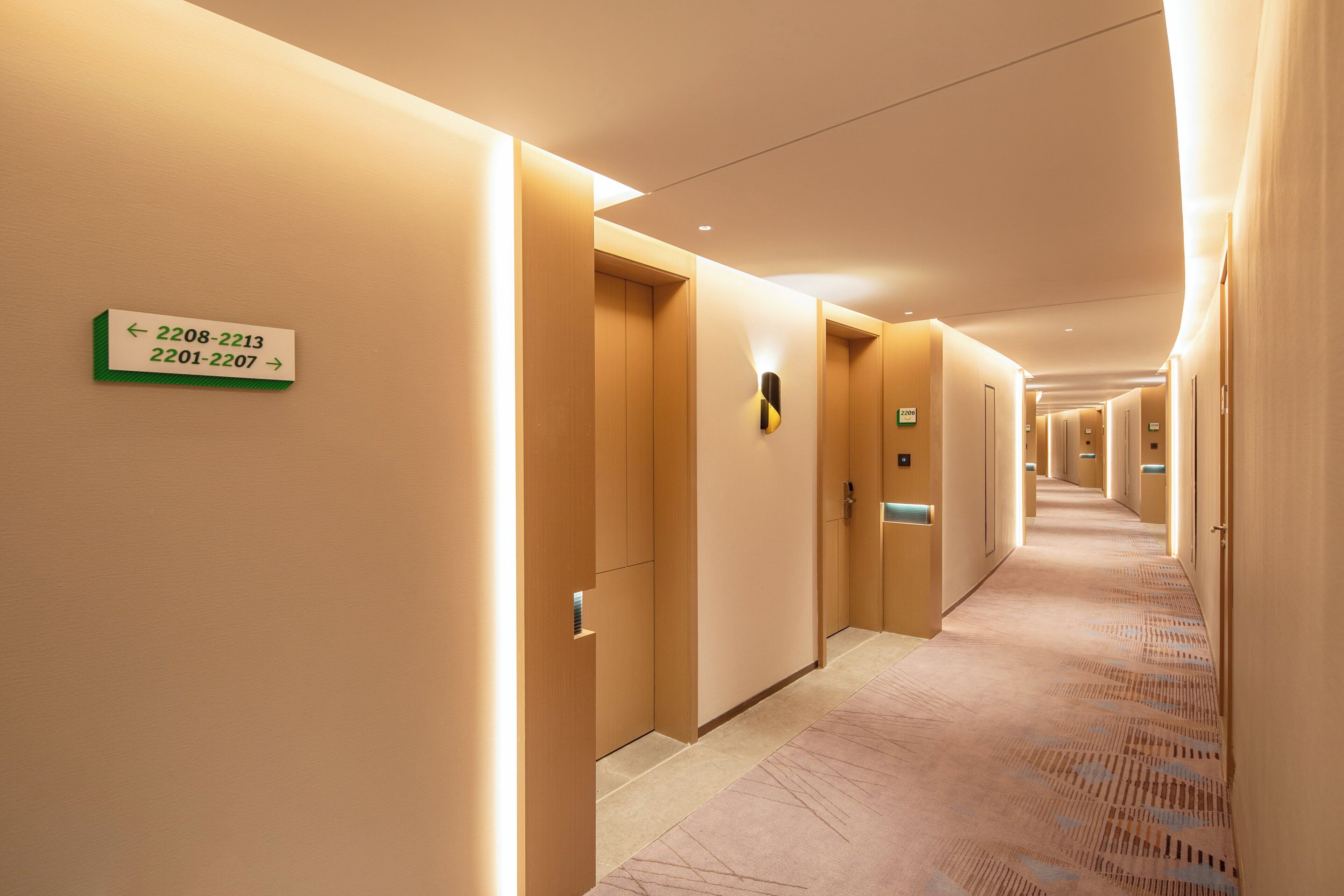 Un pasillo de hotel con puertas numeradas del 2208 al 2213 y del 2201 al 2207.