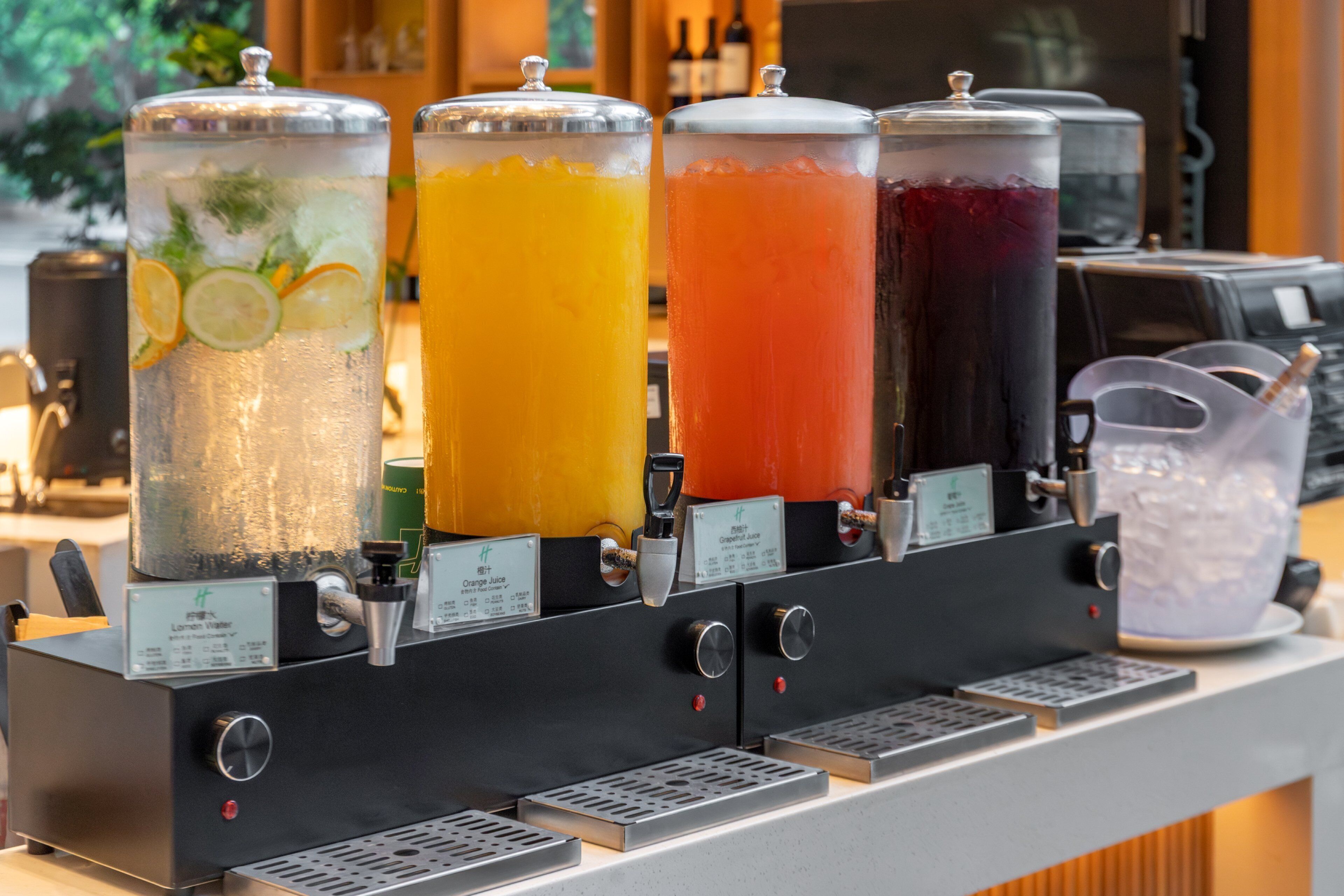 Un distributore automatico di bevande con diversi contenitori, ognuno etichettato con una bevanda diversa.