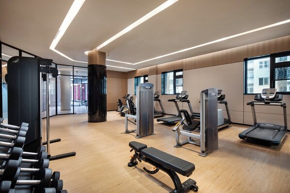 A modern gym with various exercise equipment, including treadmills, weight machines, and dumbbells. - Holiday Inn Shanghai Nanjing Road by IHG (Shanghai)