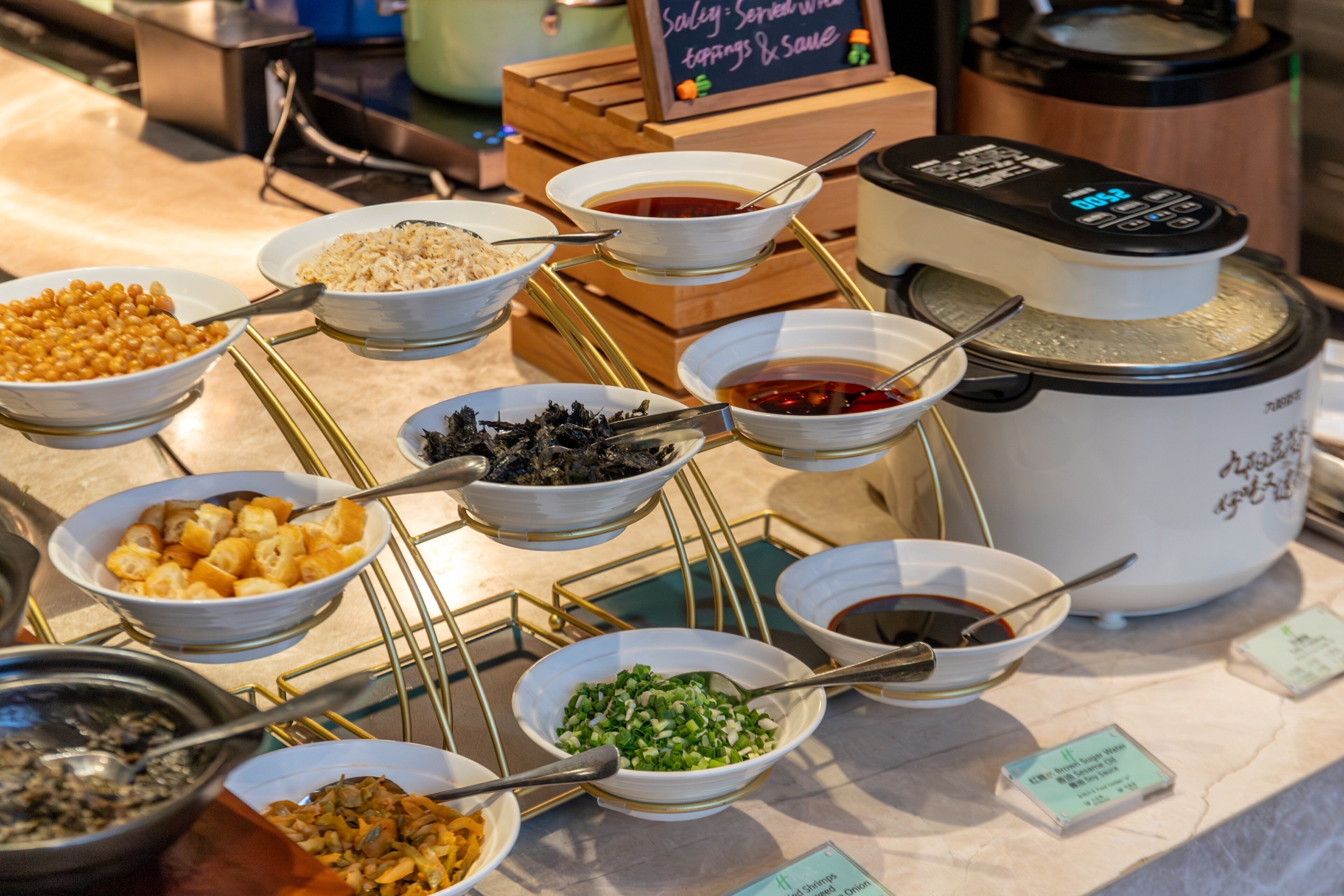 A buffet with various food items and a rice cooker.
