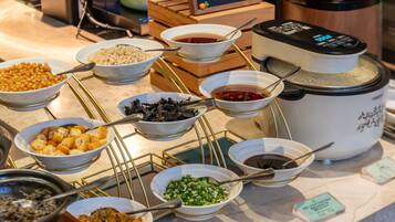 A buffet with various food items and a rice cooker.