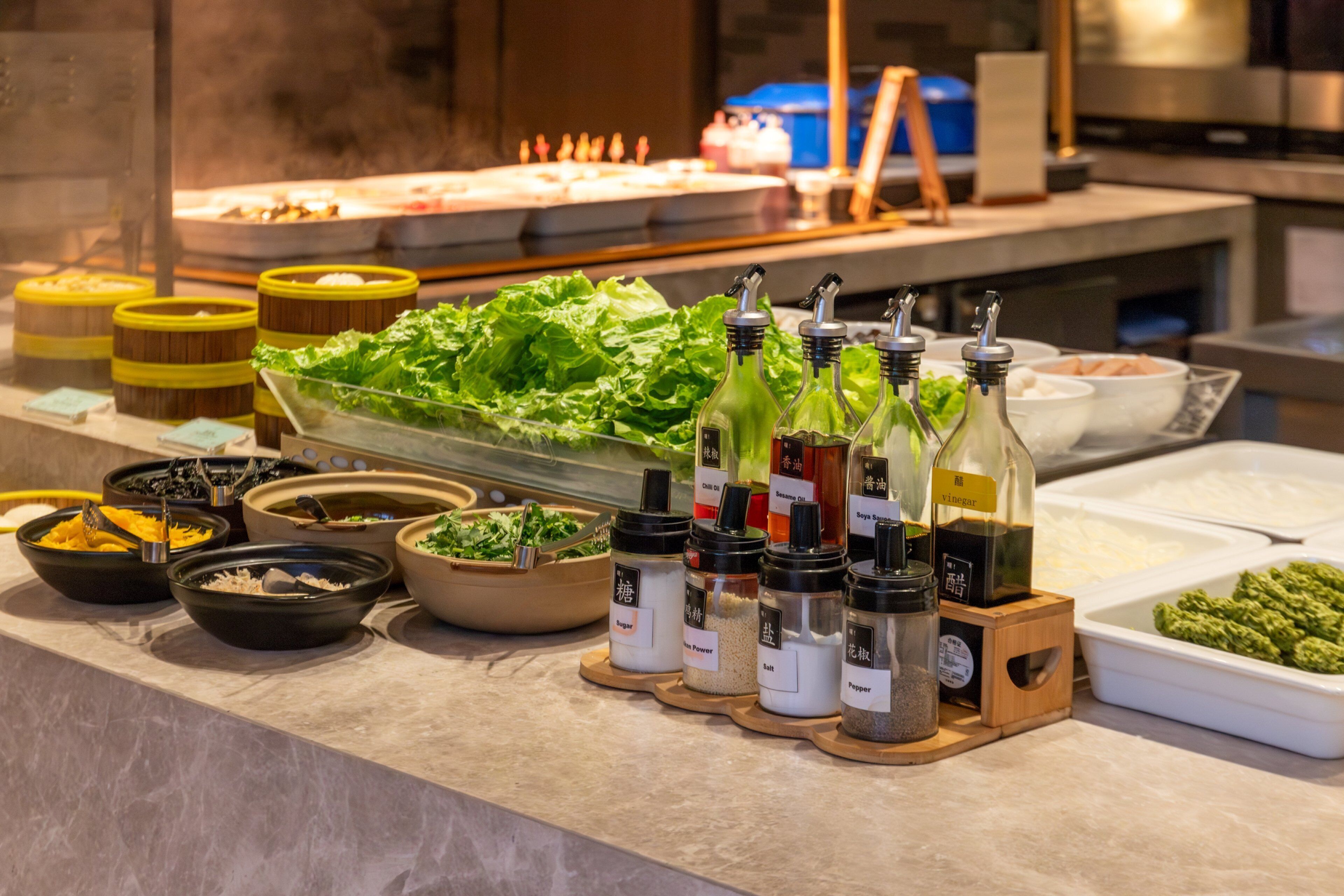 A buffet with various condiments and food items.
