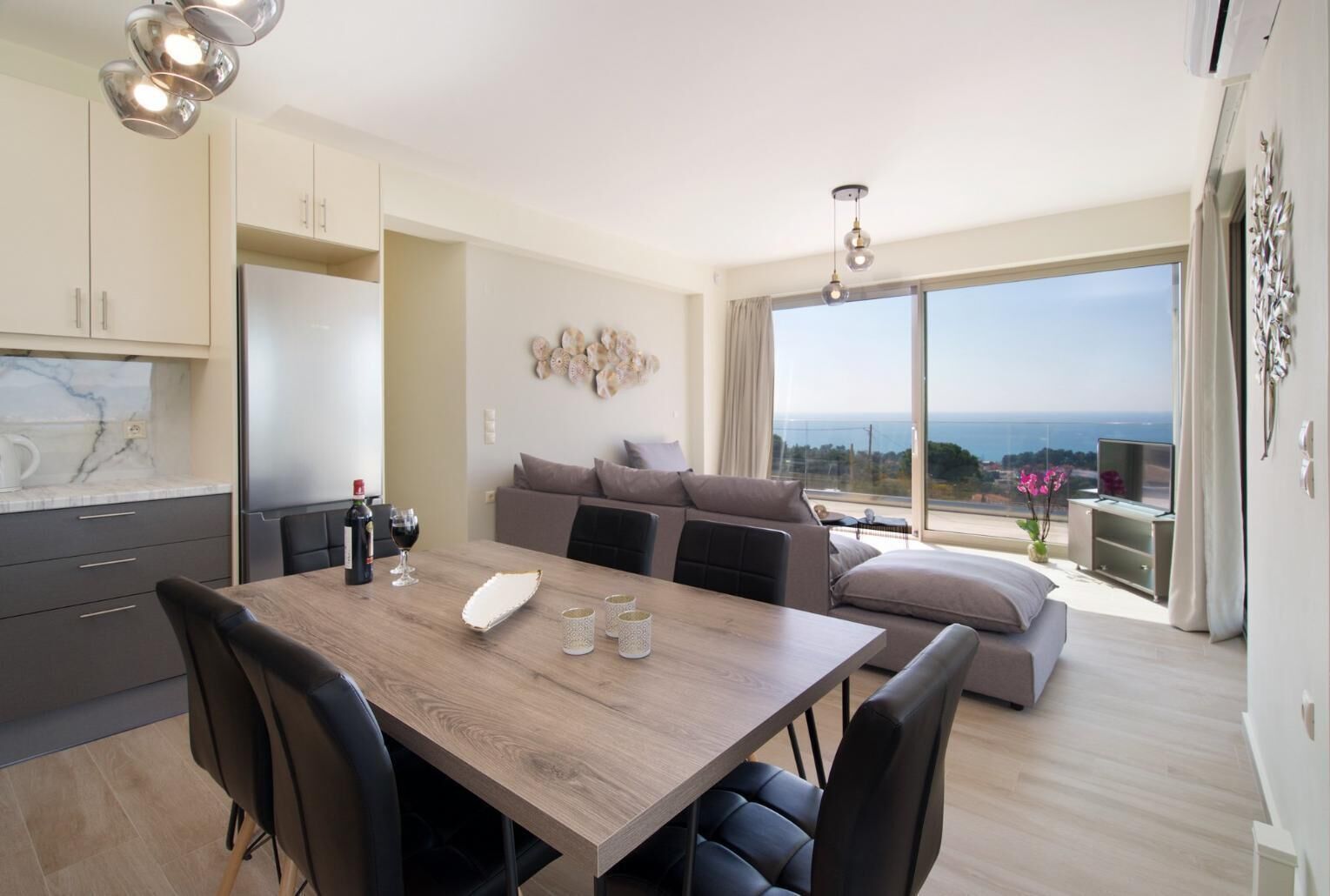 Un appartement moderne comprenant un coin repas, une cuisine et un balcon avec vue.