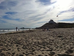 Enjoy leisure activities on this public beach with a scenic hill in the background.