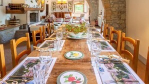 A dining area with a long wooden table set for a meal, flanked by stone arches and wooden beams. - Villa Il Giulione Large Private Pool, WiFi (Acquapendente)