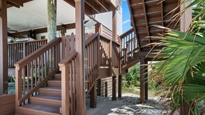 Una escalera de madera que lleva a un espacio al aire libre cubierto con vista al cielo.
