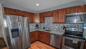 A kitchen with wooden cabinets, stainless steel appliances, and a tiled backsplash. - Cozy and Budget Friendly Single Bedroom in Denver (Denver)