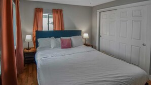 A neatly made bed with white bedding and a blue headboard, two bedside lamps, and a closed door. - Cozy and Budget Friendly Single Bedroom in Denver (Denver)