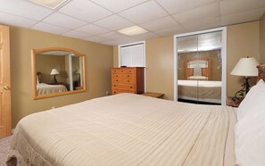 Relax in this serene space with a large bed, dresser, and window with blinds.