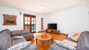 Een woonkamer met een bank, een salontafel en een televisie.