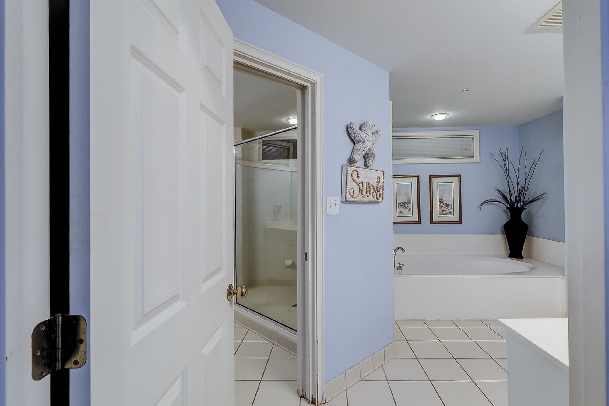 Un baño con cabina de ducha de vidrio, bañera y lavamanos.
