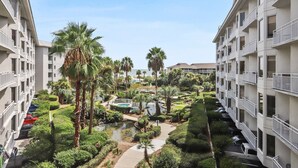 Un hôtel à plusieurs étages doté d’une cour intérieure agrémentée de palmiers, d’une petite piscine et d’un sentier pédestre.