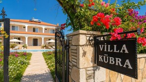 Huvila, jossa on uima-allas, portti ja kyltti, jossa lukee: ”VILLA KÜBRA”.