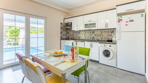 Une cuisine moderne avec un coin repas, un lave-linge et un réfrigérateur.