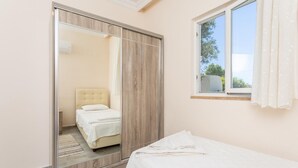 Une chambre à coucher avec un lit, une armoire et une fenêtre.