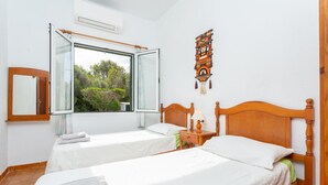 Une chambre avec deux lits, une fenêtre, un miroir et un élément décoratif mural.