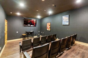 A movie theater with rows of seats, a screen, and a projector. - Splash Mansion - Indoor Pool and Theater (Sevierville)