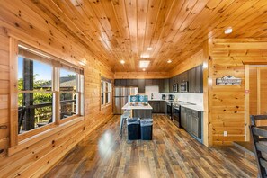 L’intérieur d’un chalet en bois comprend une cuisine, de grandes fenêtres et une vue sur l’extérieur.