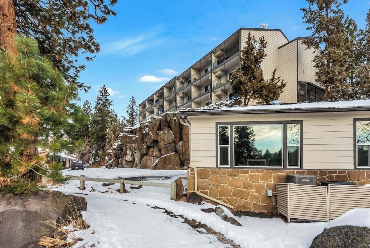 Een gebouw met een gevel van steen en hout, een pad van stenen en een met sneeuw bedekte grond.